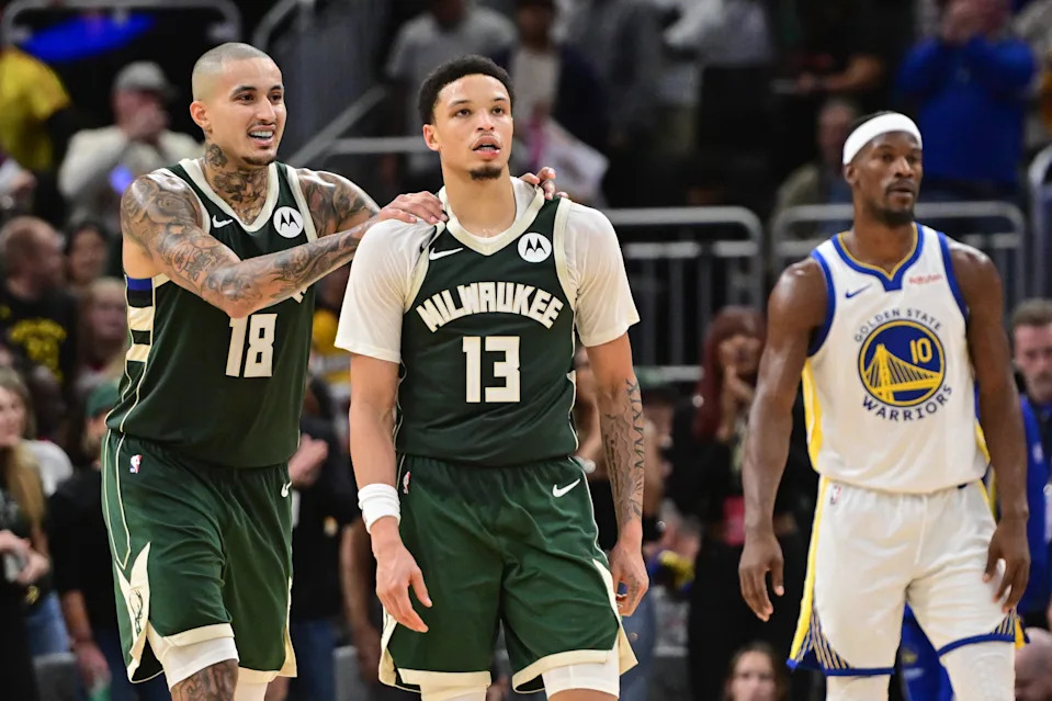 Oct 30, 2025; Milwaukee, Wisconsin, USA; Milwaukee Bucks guard Ryan Rollins (13) celebrates with forward Kyle Kuzma (18) after beating the Golden State Warriors as Warriors forward Jimmy Butler (10) looks on at Fiserv Forum. Mandatory Credit: Benny Sieu-Imagn Images