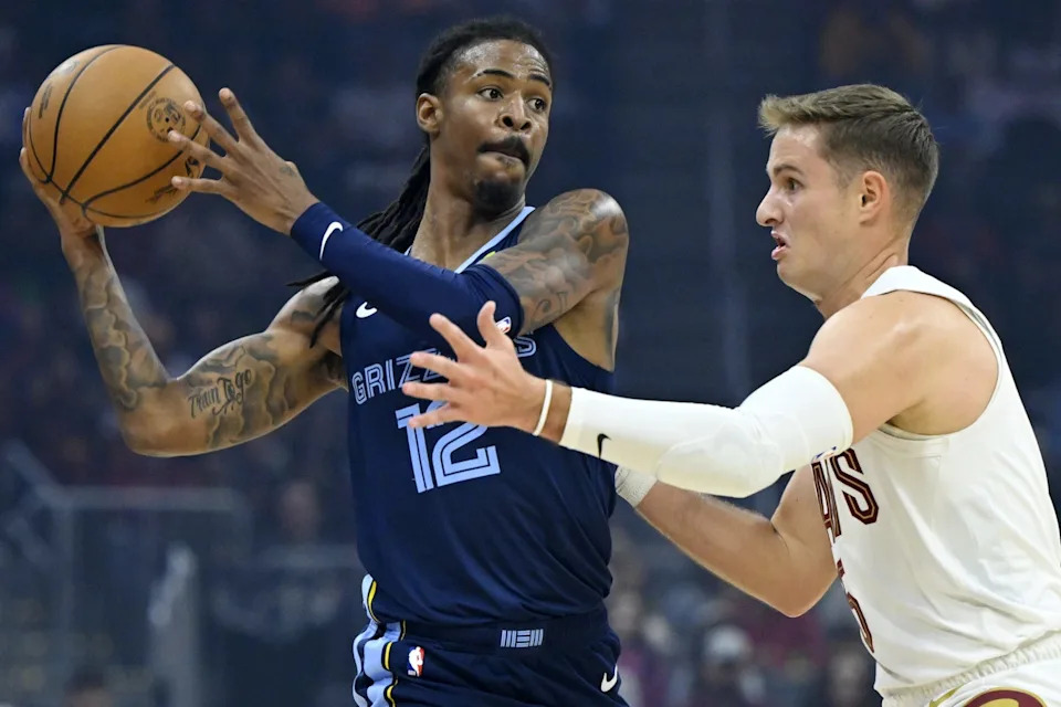 Memphis Grizzlies guard Ja Morant (12) looks to pass beside Cleveland Cavaliers guard Sam Merrill (5) in the first quarter at Rocket Arena in Cleveland, Ohio on Nov. 15, 2025.