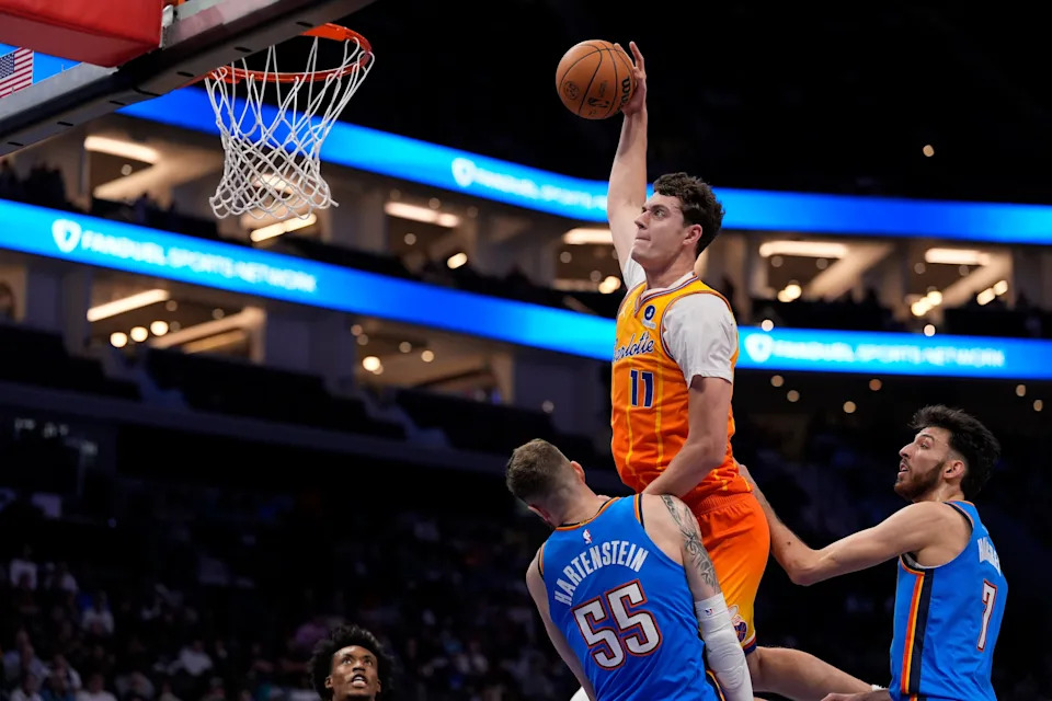 Nov 15, 2025; Charlotte, North Carolina, USA; Charlotte Hornets center Ryan Kalkbrenner (11) goes for the dunk over Oklahoma City Thunder center Isaiah Hartenstein (55) during the first quarter at Spectrum Center. Mandatory Credit: Jim Dedmon-Imagn Images