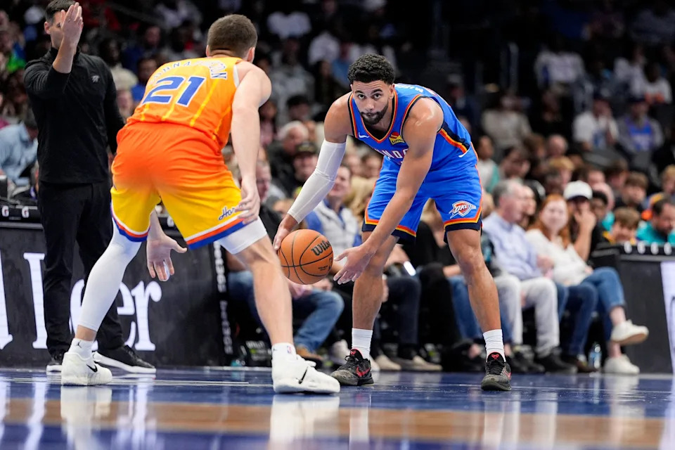 Nov 15, 2025; Charlotte, North Carolina, USA; Oklahoma City Thunder guard Ajay Mitchell (25) handles the ball defended by Charlotte Hornets guard Pat Connaughton (21) during the second half at Spectrum Center. Mandatory Credit: Jim Dedmon-Imagn Images
