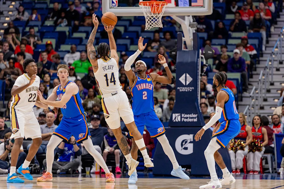 Nov 17, 2025; New Orleans, Louisiana, USA; New Orleans Pelicans guard/forward Micah Peavy (14) shoots a jump shoot against Oklahoma City Thunder guard Shai Gilgeous-Alexander (2) during the first half at Smoothie King Center. Mandatory Credit: Stephen Lew-Imagn Images