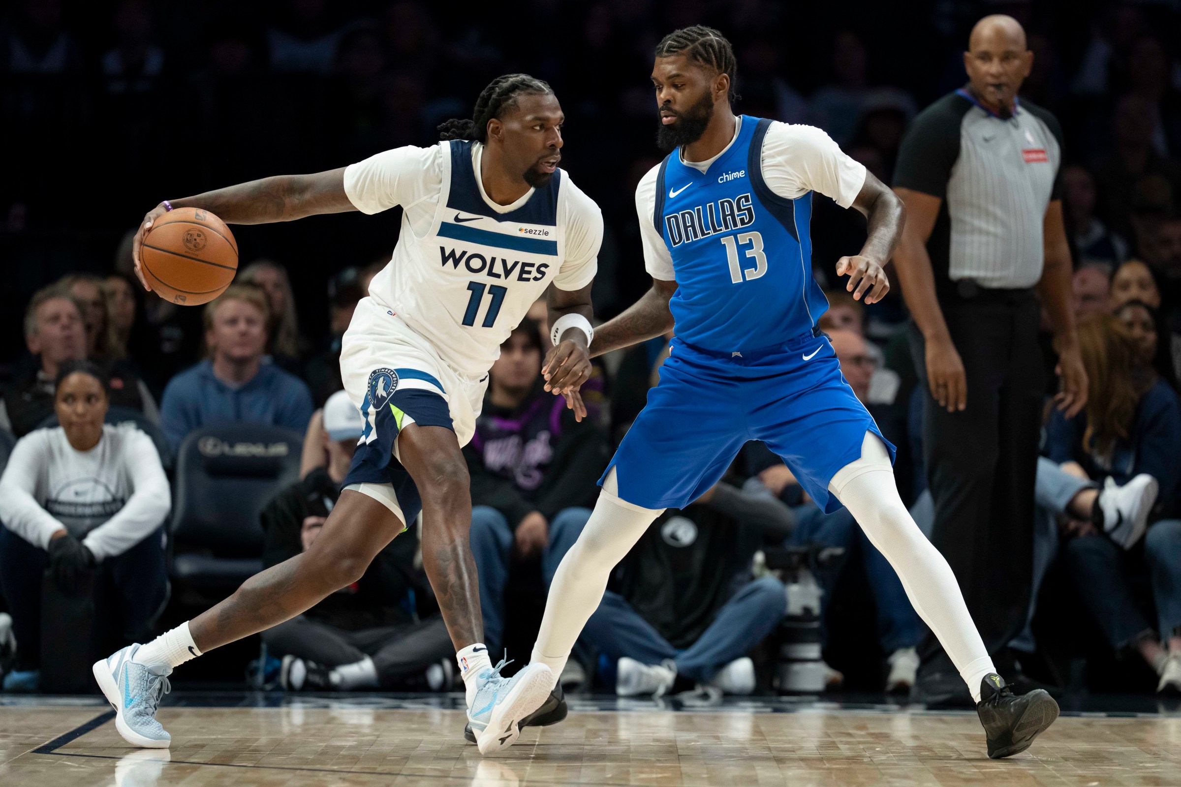 Nov 17, 2025; Minneapolis, Minnesota, USA; Minnesota Timberwolves center Naz Reid (11) dribbles the ball as Dallas Mavericks forward Naji Marshall (13) plays defense in the first half at Target Center. Mandatory Credit: Jesse Johnson-Imagn Images
