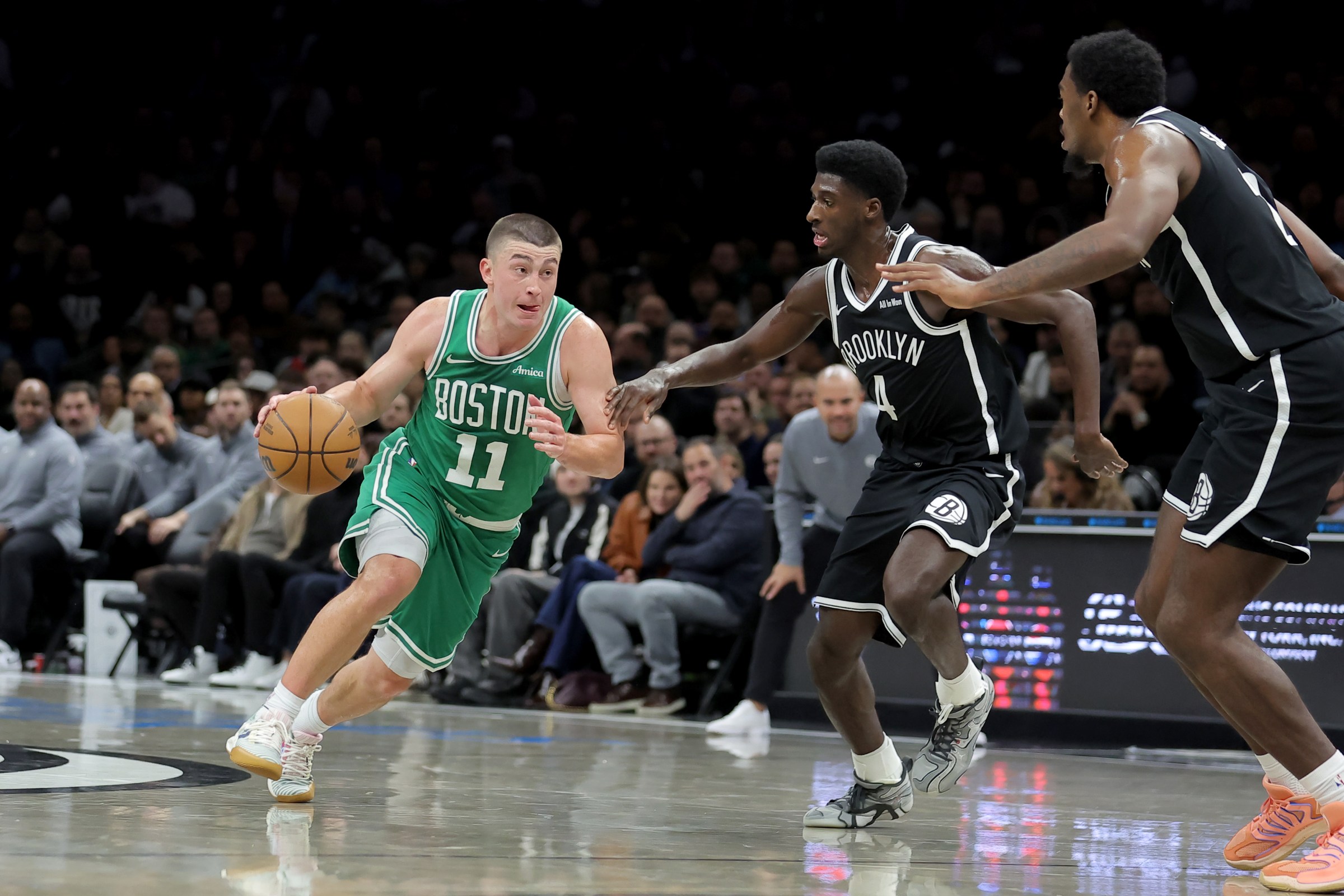 Nov 18, 2025; Brooklyn, New York, USA; Boston Celtics guard Payton Pritchard (11) brings the ball up court against Brooklyn Nets guard Drake Powell (4) and center Day’Ron Sharpe (20) during the first quarter at Barclays Center. Mandatory Credit: Brad Penner-Imagn Images