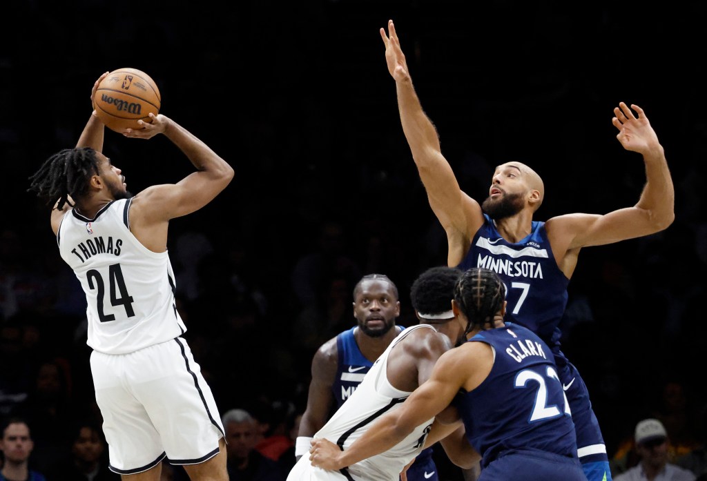 Brooklyn Nets player Cam Thomas attempts a shot over Minnesota Timberwolves player Rudy Gobert.
