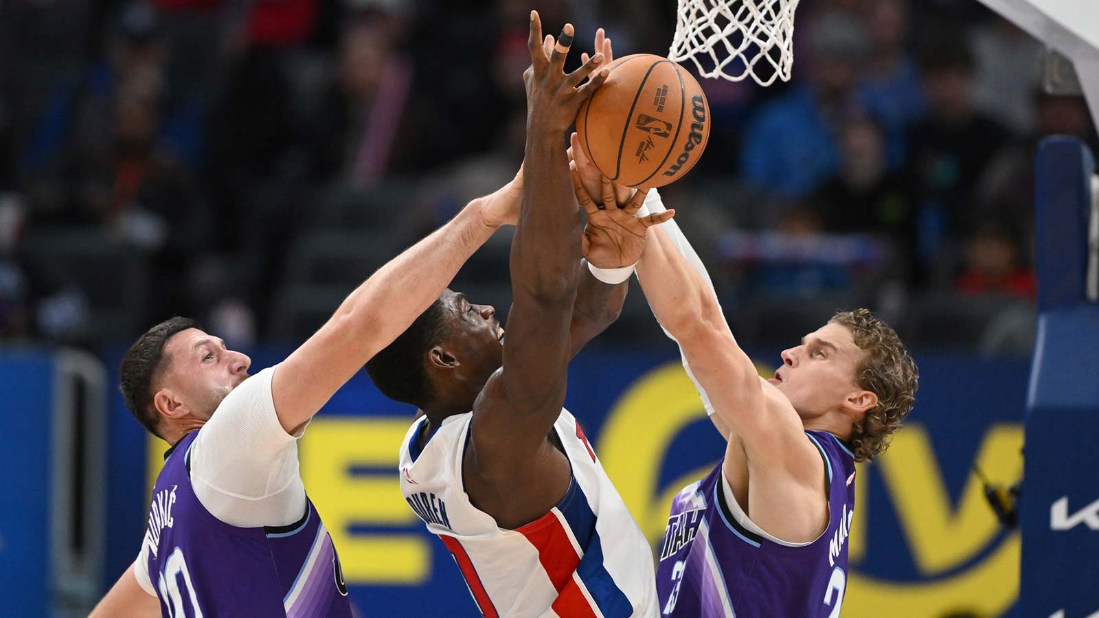 Detroit Pistons center Jalen Duren (0) is fouled by Utah Jazz center Jusuf Nurkic (30) and forward Lauri Markkanen (23) while driving to the basket in the first quarter at Little Caesars Arena.