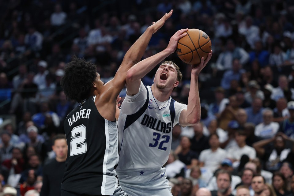 Cooper Flagg #32 of the Dallas Mavericks is fouled by Dylan Harper #2 of the San Antonio Spurs