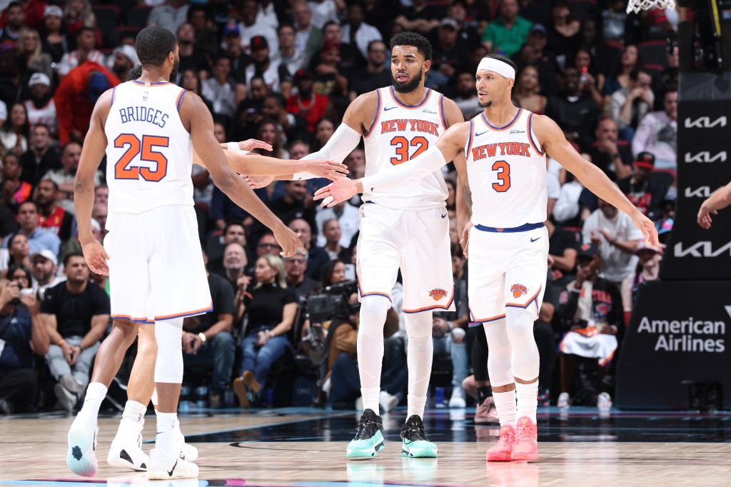New York Knicks players high-fiving during a game against the Miami Heat.