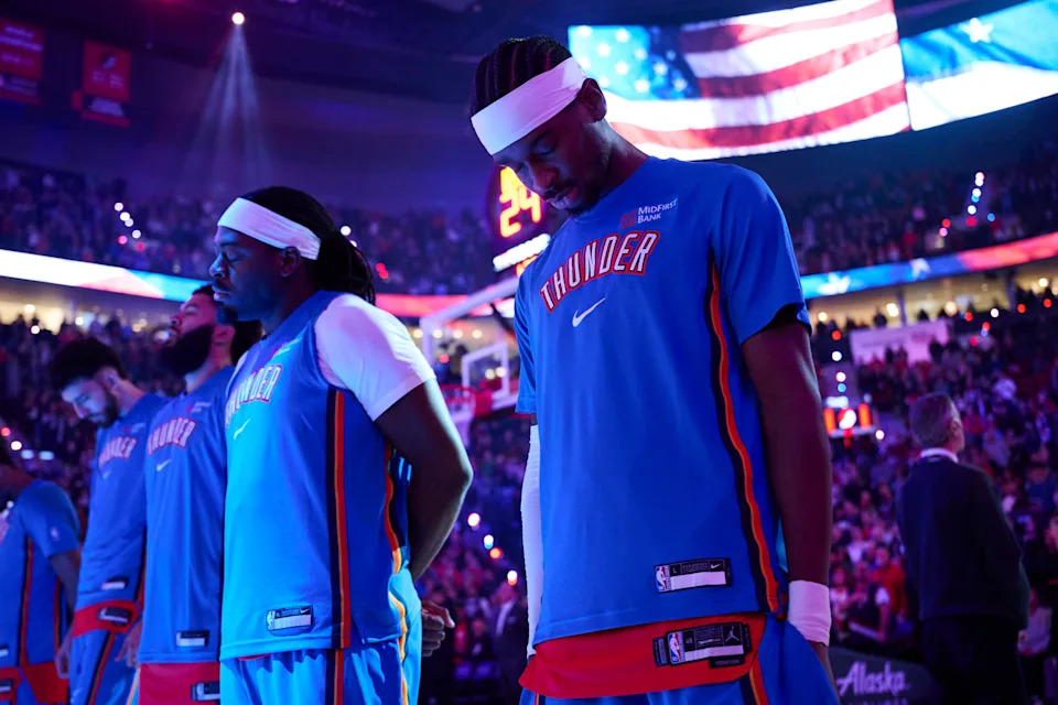 Nov 30, 2025; Portland, Oregon, USA; Oklahoma City Thunder guard Shai Gilgeous-Alexander (2) stands with teammates during the singing of the national anthem before a game against the Portland Trail Blazers at Moda Center. Mandatory Credit: Troy Wayrynen-Imagn Images