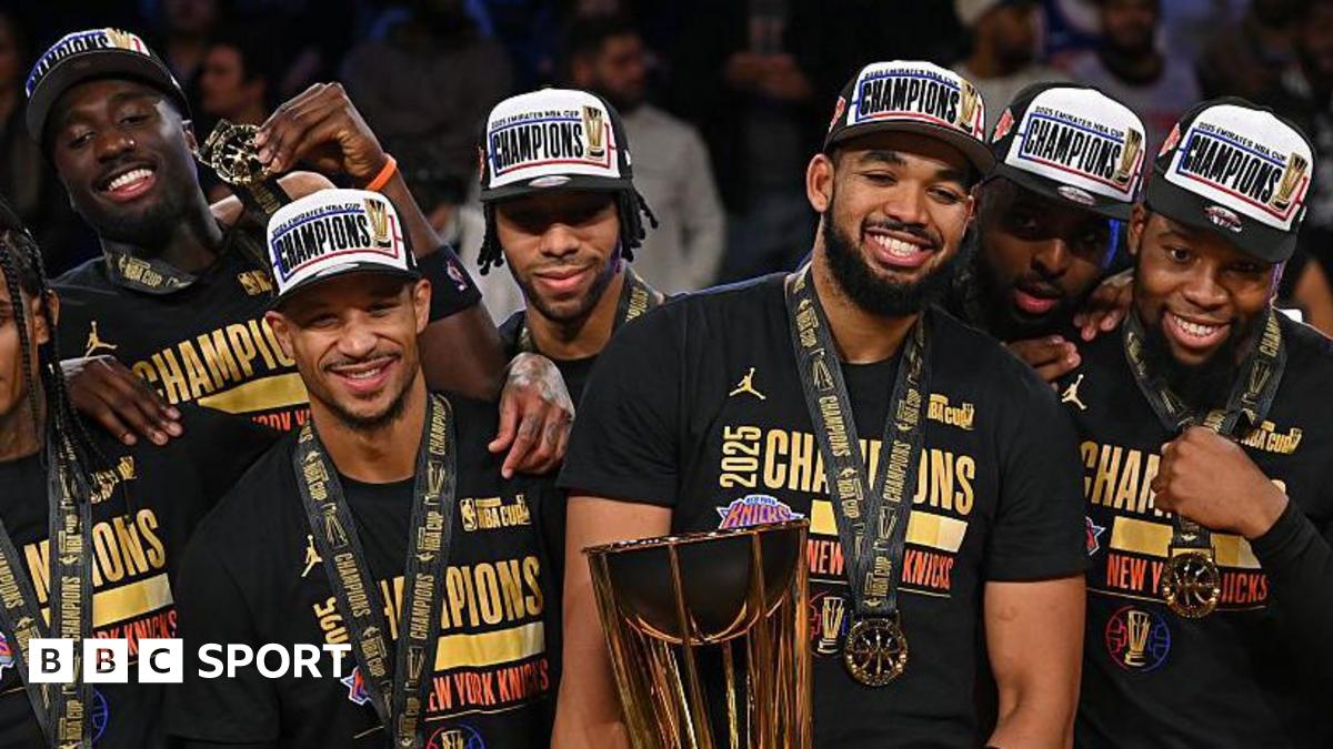 Karl-Anthony Towns holds the NBA Cup trophy besides his team-mates after the New York Knicks beat the San Antonio Spurs