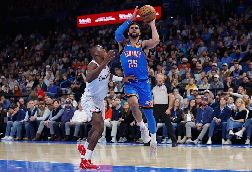 Dec 18, 2025; Oklahoma City, Oklahoma, USA; Oklahoma City Thunder guard Ajay Mitchell (25) drives to the basket beside Los Angeles Clippers guard Kris Dunn (8) during the second quarter at Paycom Center. Mandatory Credit: Alonzo Adams-Imagn Images