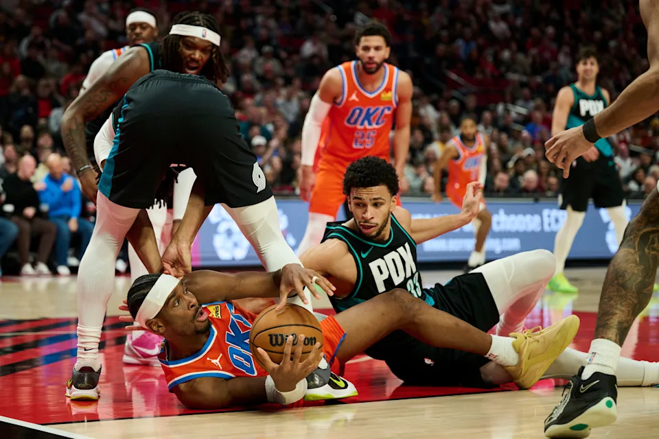 Nov 30, 2025; Portland, Oregon, USA; Oklahoma City Thunder guard Shai Gilgeous-Alexander (2) scrambles to control the ball during the second half against Portland Trail Blazers guard Shaedon Sharpe (17) and forward Toumani Camara (33) at Moda Center. Mandatory Credit: Troy Wayrynen-Imagn Images
