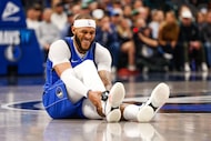 Dallas Mavericks forward Daniel Gafford (21) holds his ankle in pain during the second half...