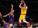 Los Angeles Lakers guard Luka Doncic shoots as Phoenix Suns forward Dillon Brooks defends.