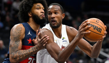 Cleveland Cavaliers center Evan Mobley, right, drives to the basket against Washington Wizards forward Marvin Bagley III, left, during the first half of an NBA basketball game Friday, Dec. 12, 2025, in Washington. (AP Photo/John McDonnell)