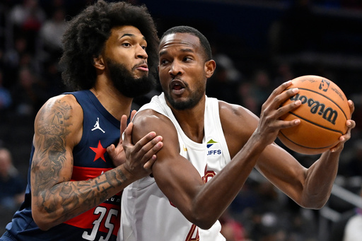 Cleveland Cavaliers center Evan Mobley, right, drives to the basket against Washington Wizards forward Marvin Bagley III, left, during the first half of an NBA basketball game Friday, Dec. 12, 2025, in Washington. (AP Photo/John McDonnell)