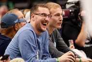 Dallas Mavericks forward Cooper Flagg’s brothers Hunter, left, and Ace watch the game...
