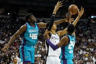 Charlotte Hornets' James Nnaji, left, and San Antonio Spurs' Victor Wembanyama battle for a...