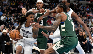 Memphis Grizzlies guard Ja Morant (12) drives against Milwaukee Bucks guard Kevin Porter Jr. (7) as Bucks center Myles Turner (3) and Grizzlies center Christian Koloko, back right, move for position in the first half of an NBA basketball game Friday, Dec. 26, 2025, in Memphis, Tenn. (AP Photo/Brandon Dill)