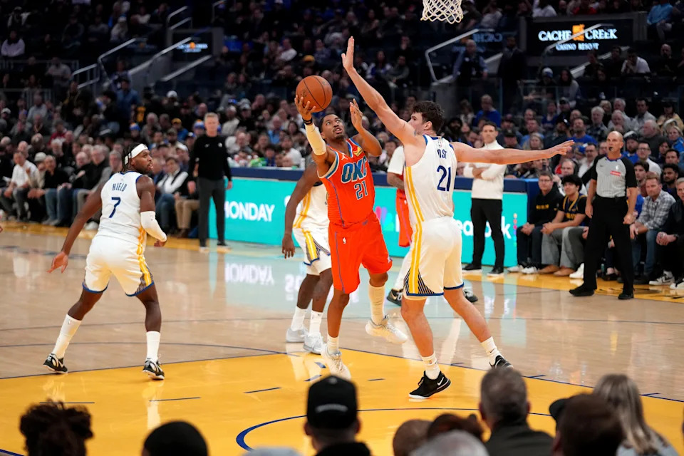 Dec 2, 2025; San Francisco, California, USA; Oklahoma City Thunder forward Aaron Wiggins (21) shoots the ball around the reach of Golden State Warriors center Quinten Post (21) in the third quarter at the Chase Center. Mandatory Credit: Cary Edmondson-Imagn Images