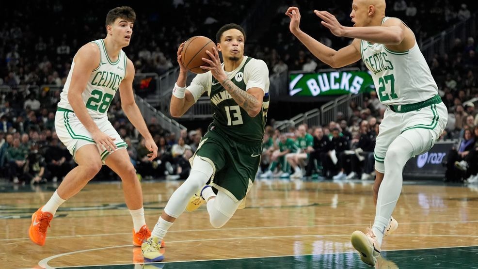 Milwaukee Bucks' Ryan Rollins (13) drives to the basket between Boston Celtics' Jordan Walsh (27) and Hugo Gonzalez (28) during the first half of an NBA basketball game Thursday, Dec. 11, 2025, in Milwaukee. (AP Photo/Aaron Gash)
