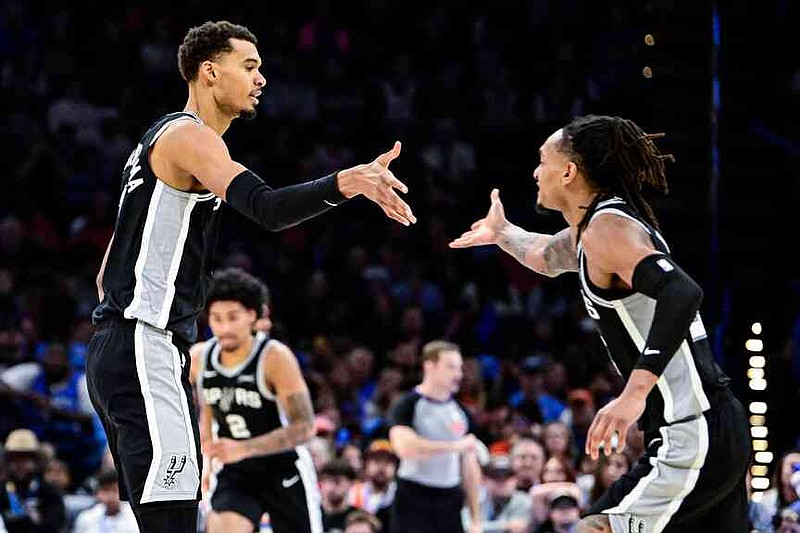 San Antonio Spurs forward/center Victor Wembanyama (1) celebrates with San Antonio Spurs guard/forward Devin Vassell (24) during the second half of an NBA basketball game, Thursday, Dec. 25, 2025, in Oklahoma City. (AP Photo/Gerald Leong)