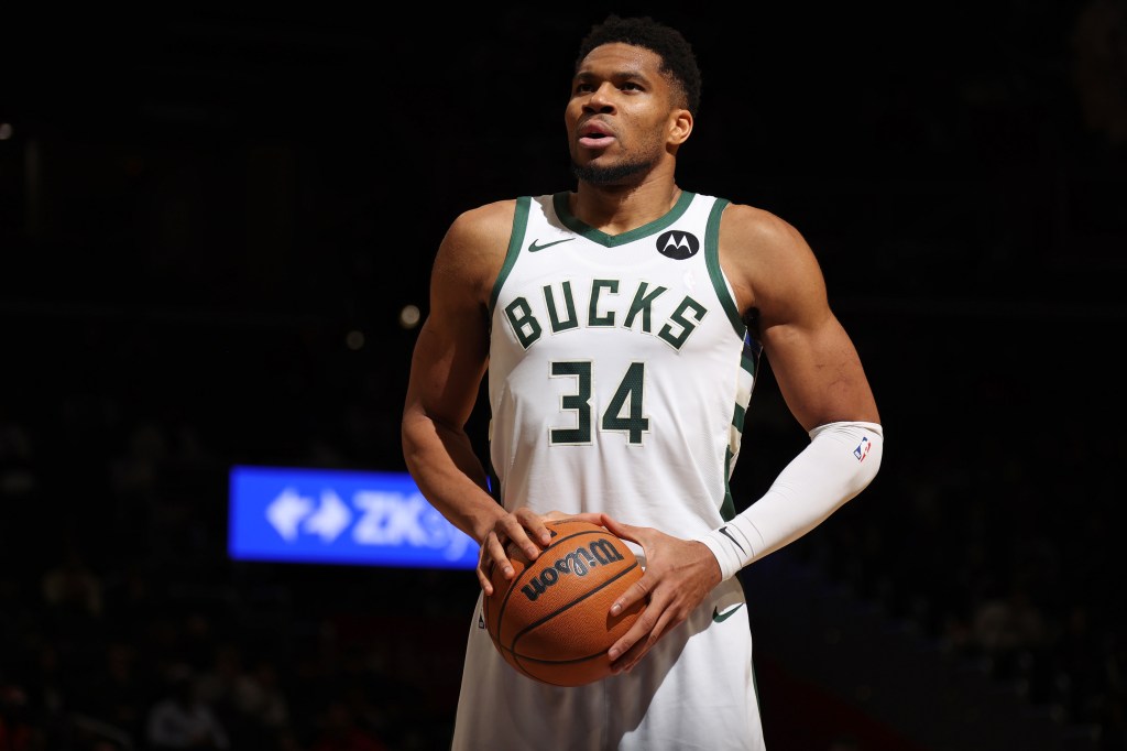 Milwaukee Bucks player Giannis Antetokounmpo holding a basketball.