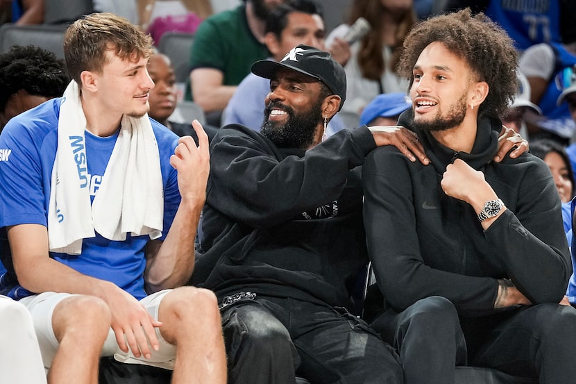 Dallas Mavericks forward Cooper Flagg (from left) laughs on the bench with guard Kyrie...