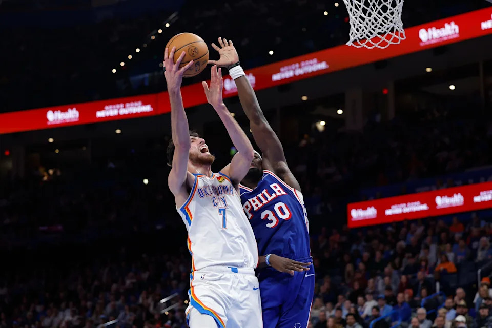 Dec 28, 2025; Oklahoma City, Oklahoma, USA; Oklahoma City Thunder center Chet Holmgren (7) goes up for a basket beside Philadelphia 76ers center Adem Bona (30) during the second half at Paycom Center. Mandatory Credit: Alonzo Adams-Imagn Images