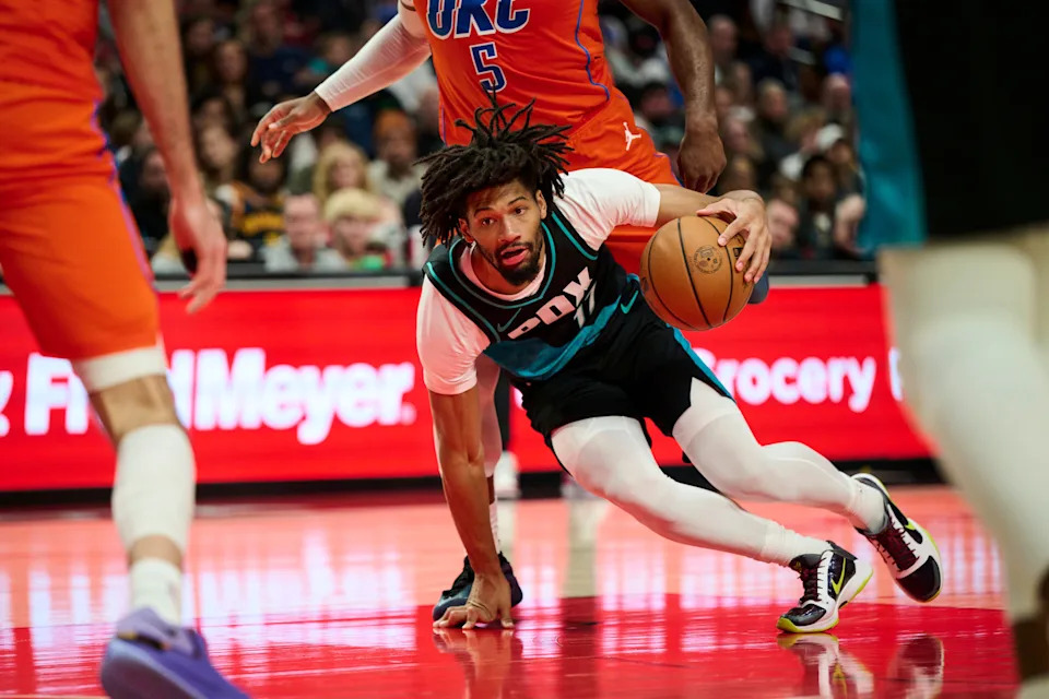 Nov 30, 2025; Portland, Oregon, USA; Portland Trail Blazers guard Shaedon Sharpe (17) falls on his way to the hoop during the second half against Oklahoma City Thunder guard Luguentz Dort (5) at Moda Center. Mandatory Credit: Troy Wayrynen-Imagn Images