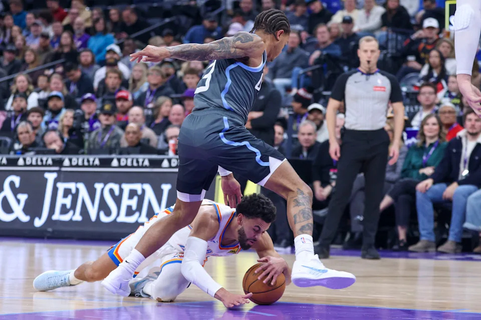 Dec 7, 2025; Salt Lake City, Utah, USA; Oklahoma City Thunder guard Ajay Mitchell (25) falls to the floor for the ball against Utah Jazz guard Keyonte George (3) during the first quarter at Delta Center. Mandatory Credit: Rob Gray-Imagn Images