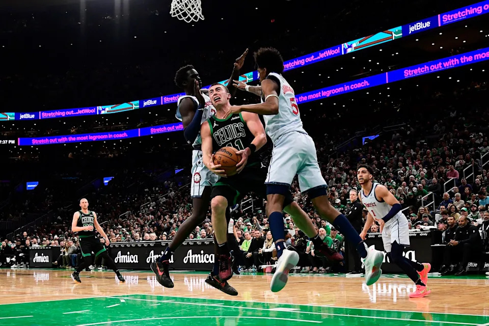 Apr 6, 2025; Boston, Massachusetts, USA; Boston Celtics guard Payton Pritchard (11) gets sandwiched between Washington Wizards forward JT Thor (21) and guard AJ Johnson (5) during the second half at TD Garden. Mandatory Credit: Bob DeChiara-Imagn Images
