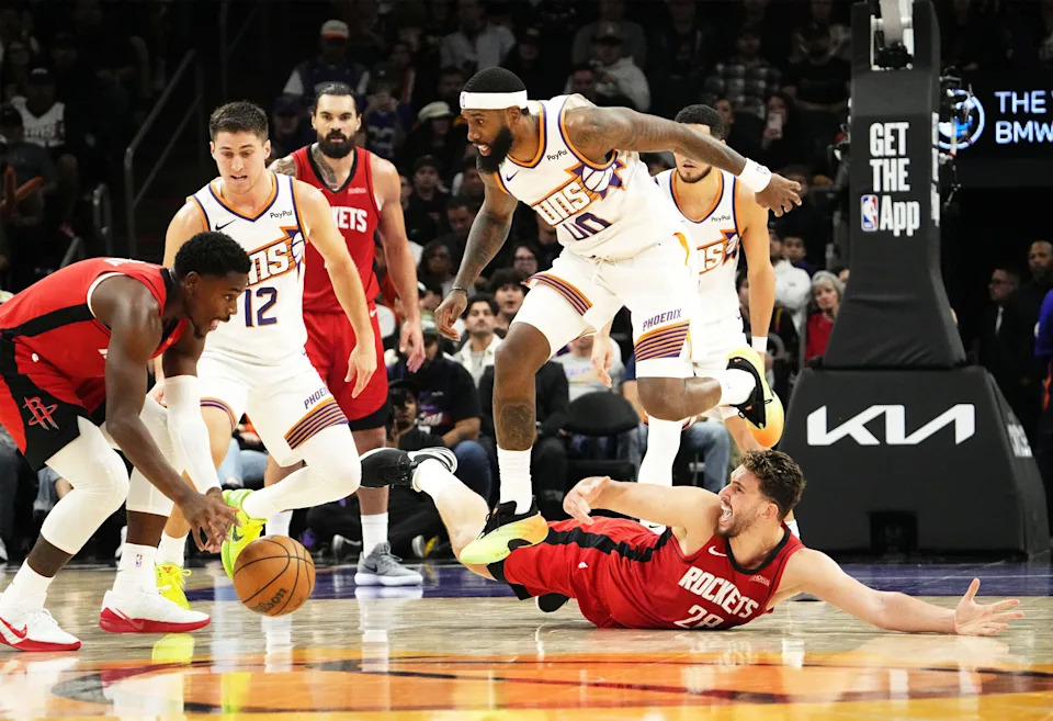 Phoenix Suns forward Royce O'Neale (00) jumps over Houston Rockets center Alperen Sengun (28) in the second half at Mortgage Matchup Center on Nov. 24, 2025, in Phoenix.