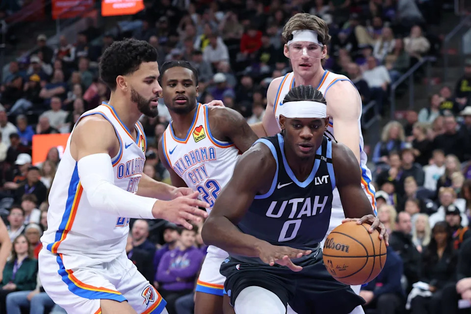 Dec 7, 2025; Salt Lake City, Utah, USA; Utah Jazz forward Taylor Hendricks (0) goes to the basket against Oklahoma City Thunder guard Ajay Mitchell (left), guard Cason Wallace (22) and center Branden Carlson (back) during the second half at Delta Center. Mandatory Credit: Rob Gray-Imagn Images
