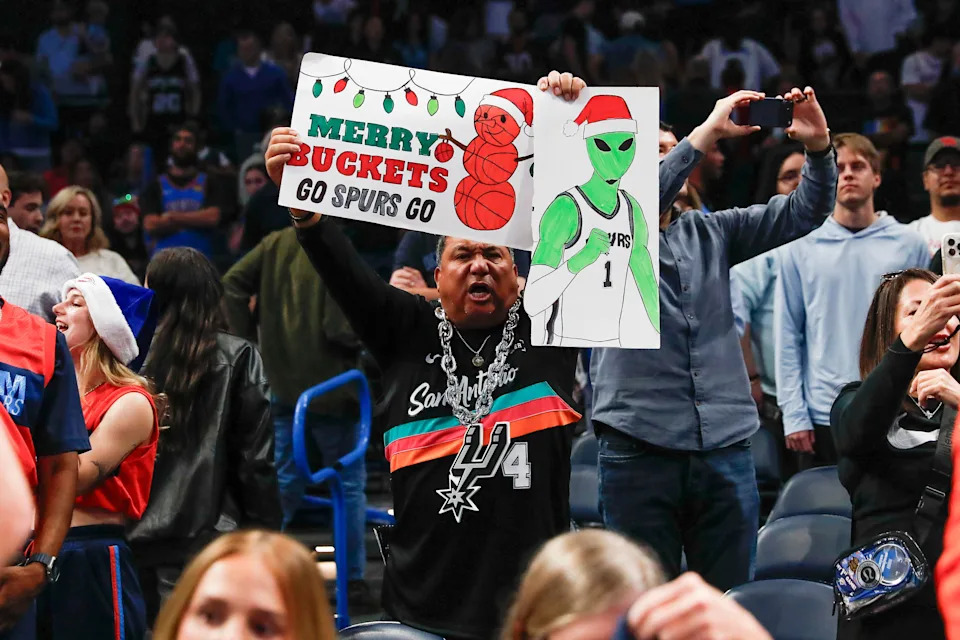 Dec 25, 2025; Oklahoma City, Oklahoma, USA; A San Antonio Spurs fan holds signs at the end of a game between the San Antonio Spurs and Oklahoma City Thunder at Paycom Center. Mandatory Credit: Alonzo Adams-Imagn Images