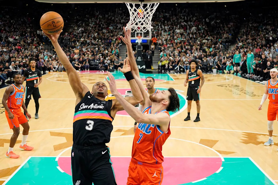 Dec 23, 2025; San Antonio, Texas, USA; San Antonio Spurs forward Keldon Johnson (3) drives to the basket against Oklahoma City Thunder center Chet Holmgren (7) during the second half at Frost Bank Center. Mandatory Credit: Scott Wachter-Imagn Images