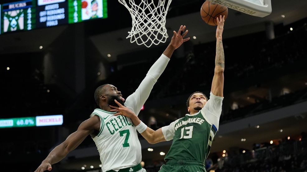 Milwaukee Bucks' Ryan Rollins (13) shoots against Boston Celtics' Jaylen Brown (7) during the first half of an NBA basketball game Thursday, Dec. 11, 2025, in Milwaukee. (AP Photo/Aaron Gash)