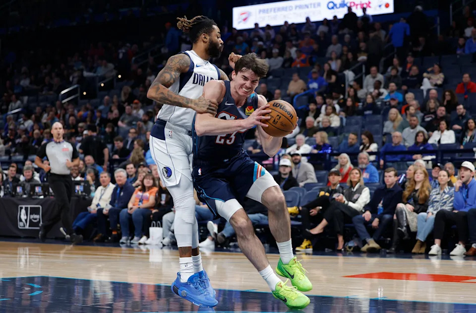Dec 5, 2025; Oklahoma City, Oklahoma, USA; Oklahoma City Thunder forward Brooks Barnhizer (23) drives past Dallas Mavericks guard D'Angelo Russell (5) during the second half at Paycom Center. Mandatory Credit: Alonzo Adams-Imagn Images