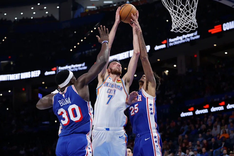Dec 28, 2025; Oklahoma City, Oklahoma, USA; Oklahoma City Thunder center Chet Holmgren (7) goes up for a basket between Philadelphia 76ers forward Dominick Barlow (25) and center Adem Bona (30) during the second half at Paycom Center. Mandatory Credit: Alonzo Adams-Imagn Images