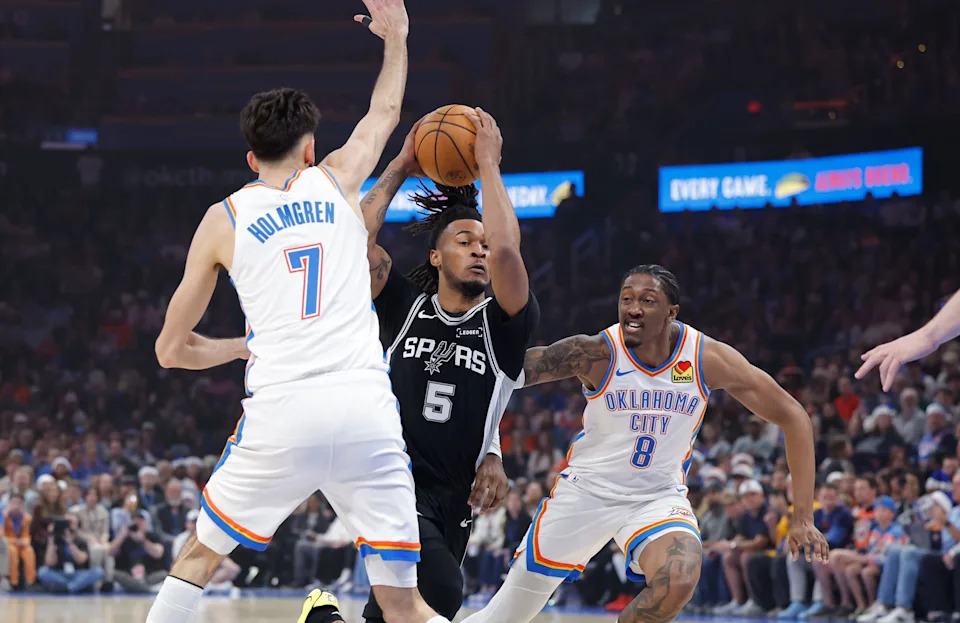 Dec 25, 2025; Oklahoma City, Oklahoma, USA; San Antonio Spurs guard Stephon Castle (5) drives between Oklahoma City Thunder guard Jalen Williams (8) and center Chet Holmgren (7) during the first quarter at Paycom Center. Mandatory Credit: Alonzo Adams-Imagn Images