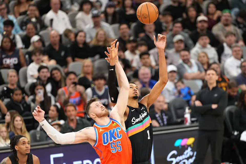 Dec 23, 2025; San Antonio, Texas, USA; San Antonio Spurs forward Victor Wembanyama (1) and Oklahoma City Thunder center Isaiah Hartenstein (55) in a jump ball during the first half at Frost Bank Center. Mandatory Credit: Scott Wachter-Imagn Images