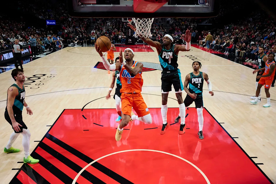 Nov 30, 2025; Portland, Oregon, USA; Oklahoma City Thunder guard Shai Gilgeous-Alexander (2) scores a basket during the first half against Portland Trail Blazers forward Jerami Grant (9) at Moda Center. Mandatory Credit: Troy Wayrynen-Imagn Images