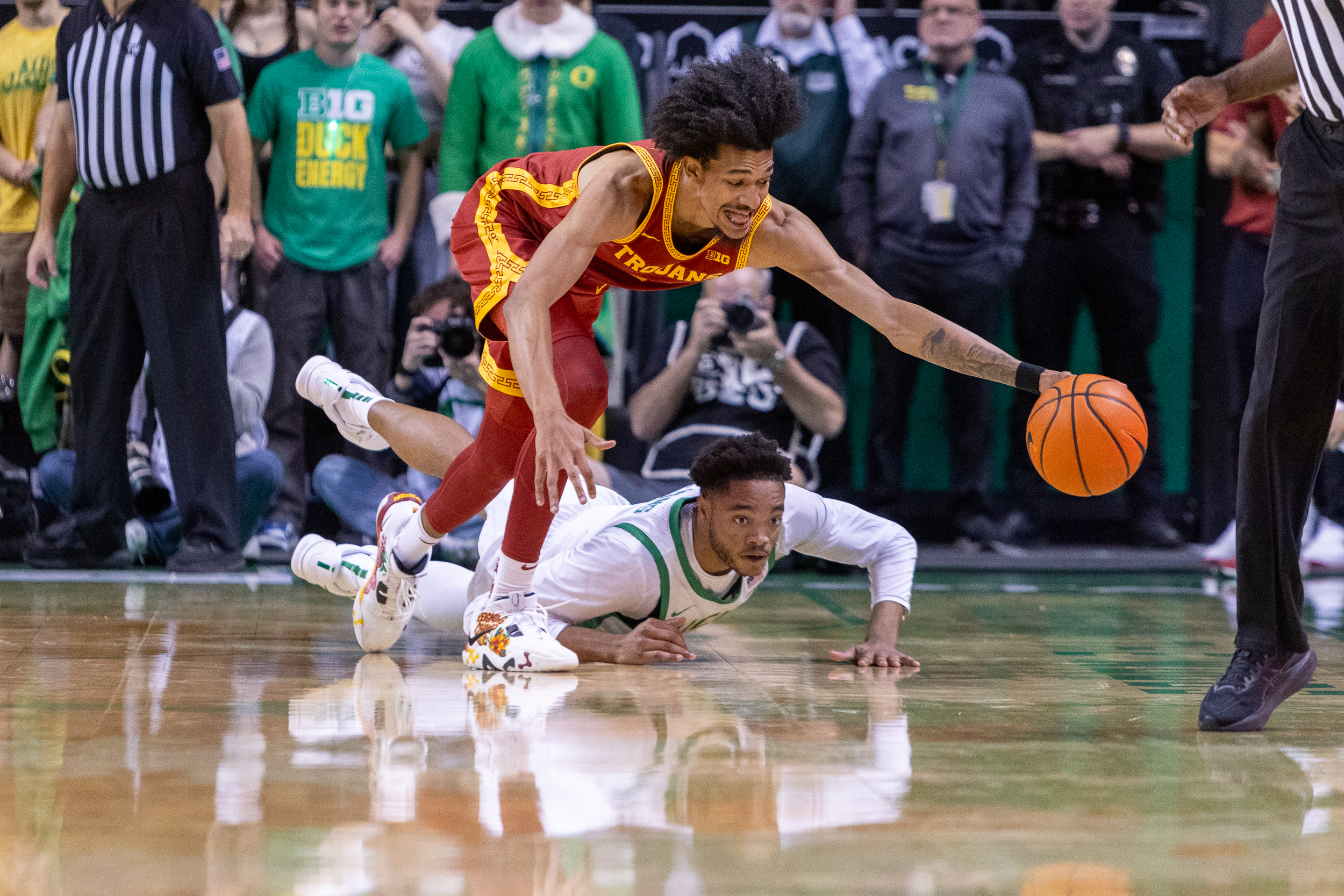 USC forward Chad Baker-Mazara dives for a loose ball against Oregon’s Kwame Evans Jr. as the Trojans face the Ducks in a Big Ten men’s college basketball at Matthew Knight Arena in Eugene on Tuesday, Dec. 2, 2025.