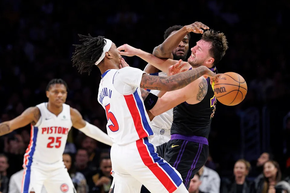 Lakers guard Luka Doncic, right, inadvertently hits Detroit Pistons forward Ronald Holland II in the face.