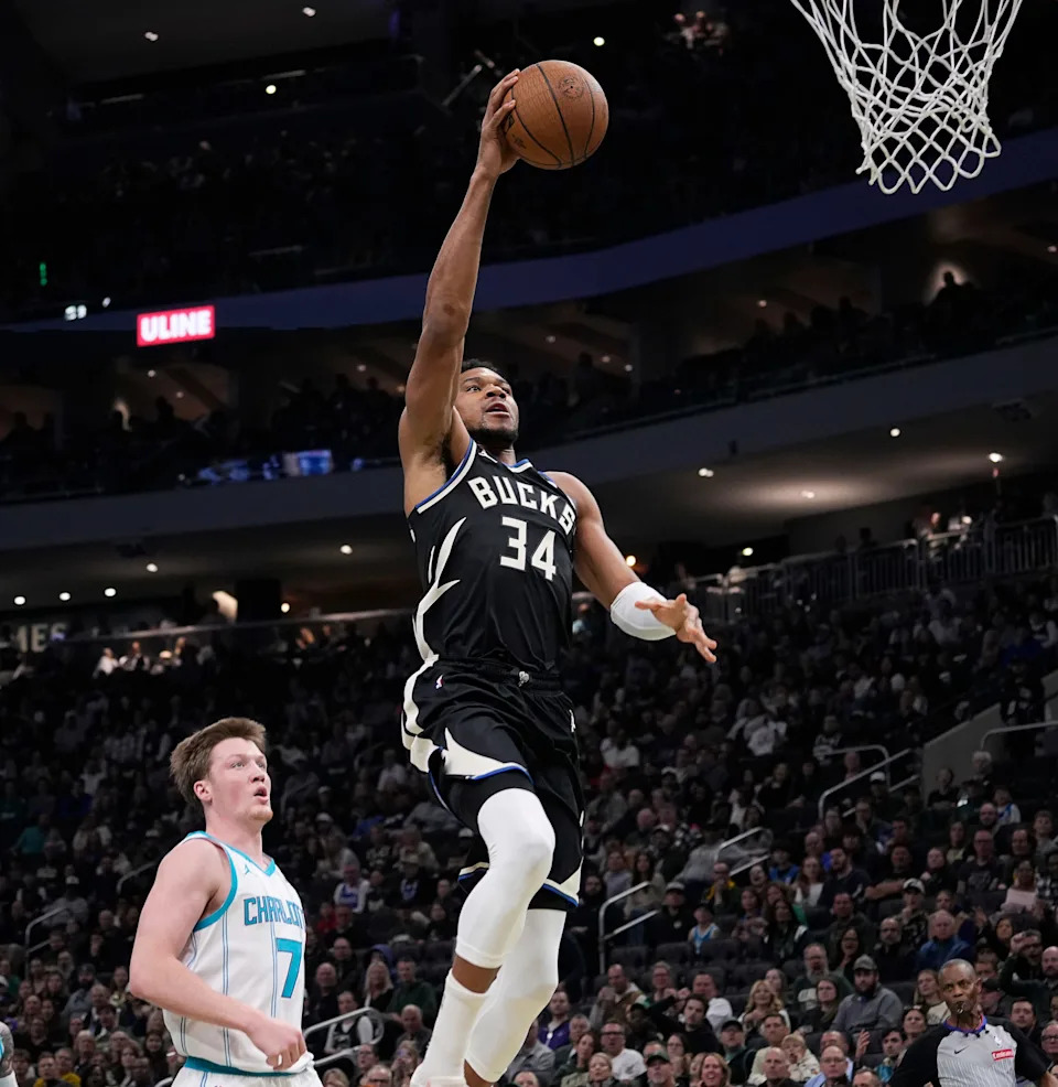 Bucks forward Giannis Antetokounmpo scores as Charlotte Hornets guard Kon Knueppel looks on during their game Nov. 14 at Fiserv Forum.
