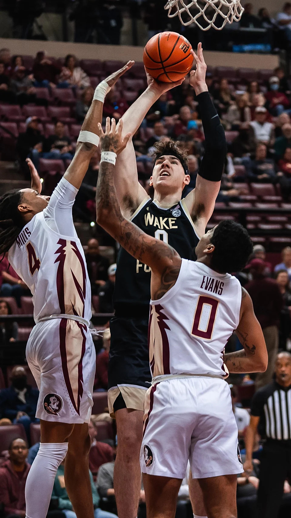 Jake LaRavia attempts a shot inside the paint while defended by two Florida State players during his time at Wake Forest