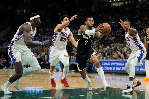 Milwaukee Bucks' Kevin Porter Jr. (7) drives to the basket against Philadelphia 76ers' Jabari Walker, right, Jared McCain (20), and Adem Bona during the first half of an NBA basketball game, Friday, Dec. 5, 2025, in Milwaukee. (AP Photo/Aaron Gash)