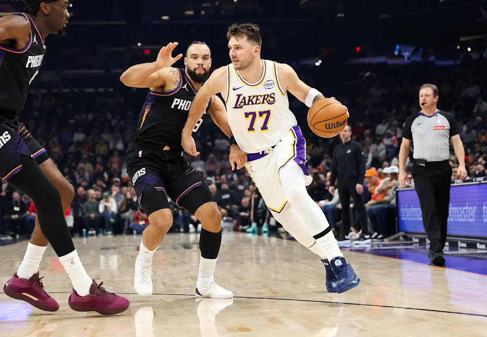 Luka Doncic #77 of the Los Angeles Lakers dribbles as Dillon Brooks #3 of the Phoenix Suns defends during the first half of a game at Mortgage Matchup Center on Dec. 14, 2025, in Phoenix.