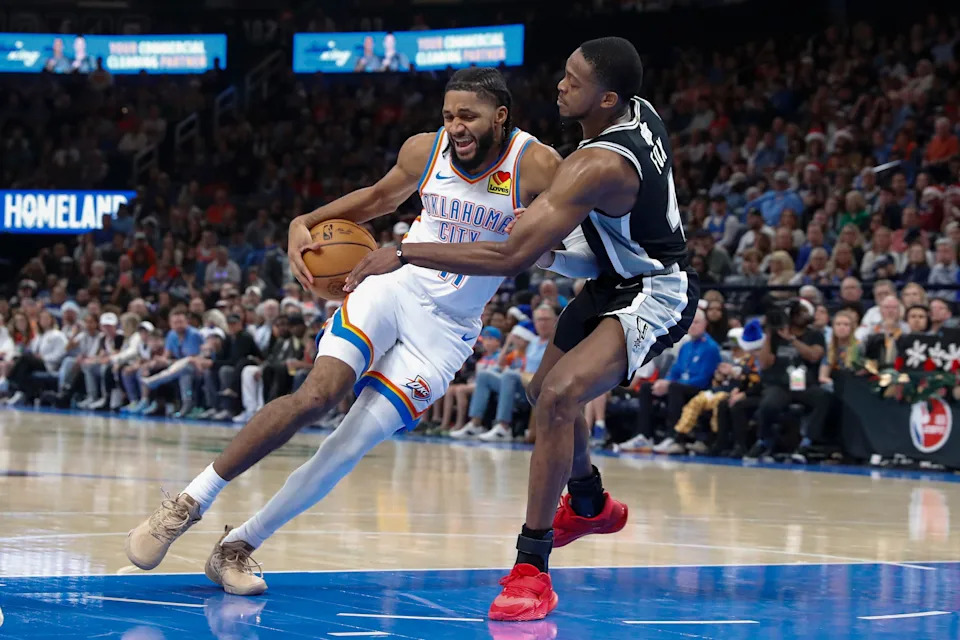 Dec 25, 2025; Oklahoma City, Oklahoma, USA; Oklahoma City Thunder guard Isaiah Joe (11) is defended by San Antonio Spurs guard De'Aaron Fox (4) on a drive during the second half at Paycom Center. Mandatory Credit: Alonzo Adams-Imagn Images
