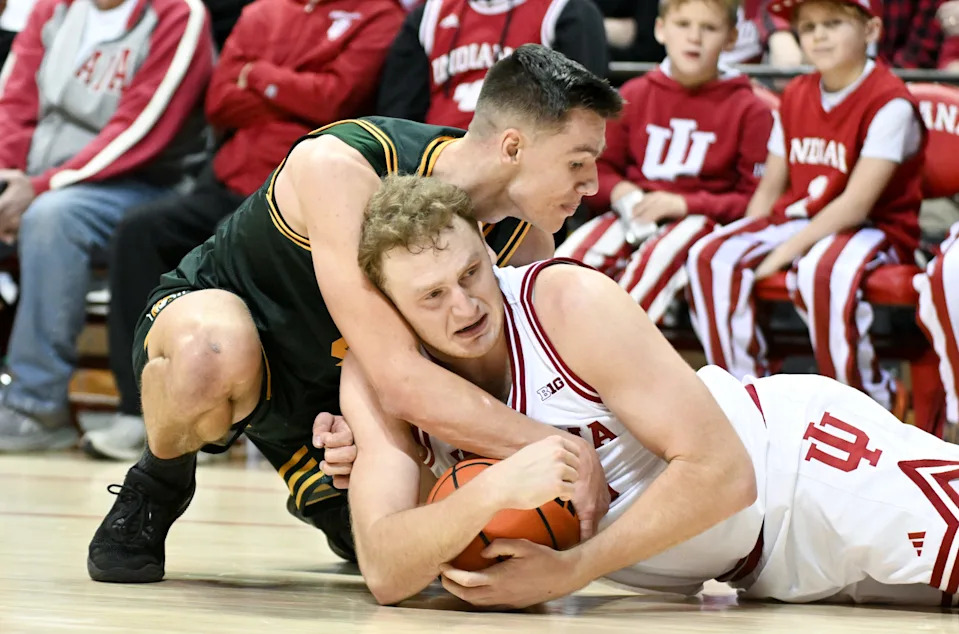 Dec 22, 2025; Bloomington, Indiana, USA; Siena Saints guard Gavin Doty (4) forces a jump ball with Indiana Hoosiers forward Tucker Devries (12) during the second half at Simon Skjodt Assembly Hall. Mandatory Credit: Robert Goddin-Imagn Images