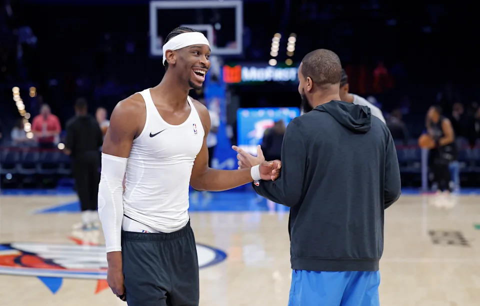 Dec 25, 2025; Oklahoma City, Oklahoma, USA; Oklahoma City Thunder guard Shai Gilgeous-Alexander laughs with an assistant coach during warms ups before a game against the San Antonio Spurs at Paycom Center. Mandatory Credit: Alonzo Adams-Imagn Images